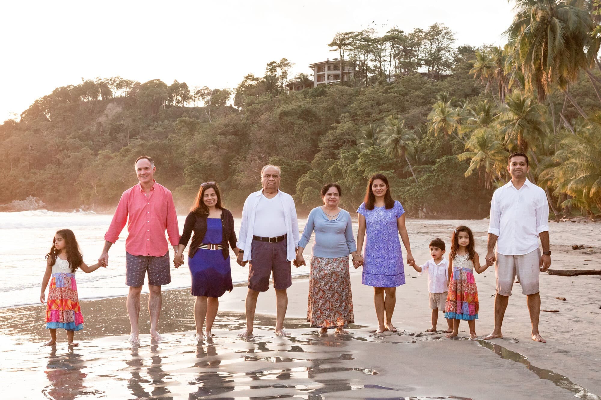 Three generations of the Majmundar family walking at the water's edge